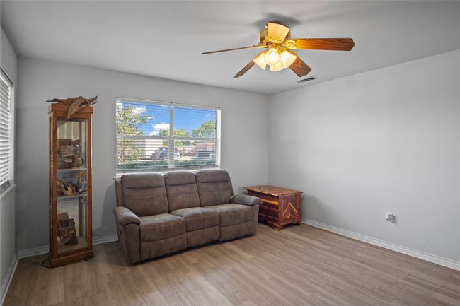 Living room with wood finished floors and a ceiling fan | Image 12