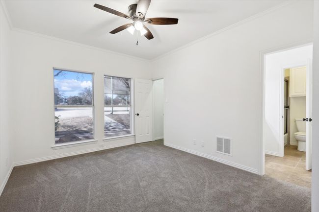 Empty room with carpet, ornamental molding, a ceiling fan, and baseboards | Image 21