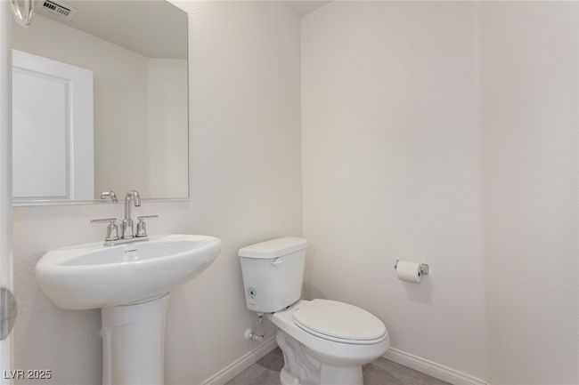 Bathroom with toilet, visible vents, and baseboards | Image 11