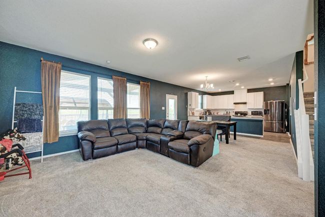 Living room featuring a chandelier, light colored carpet, stairway, and recessed lighting | Image 12