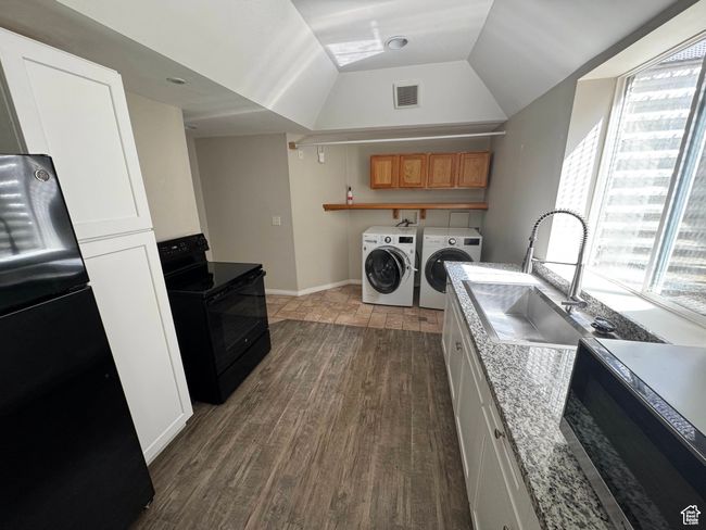 Washroom with washing machine and clothes dryer, plenty of natural light, wood finished floors, and baseboards | Image 16