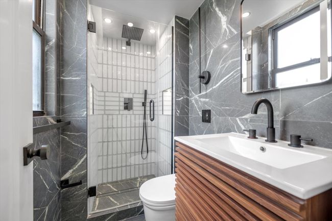 Full bath featuring tile walls, a shower stall, and vanity | Image 12