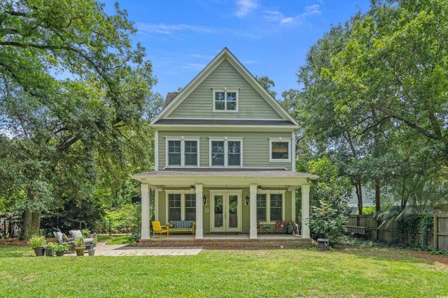 Back of house with french doors, a porch, a chimney, and roof with shingles | Image 23