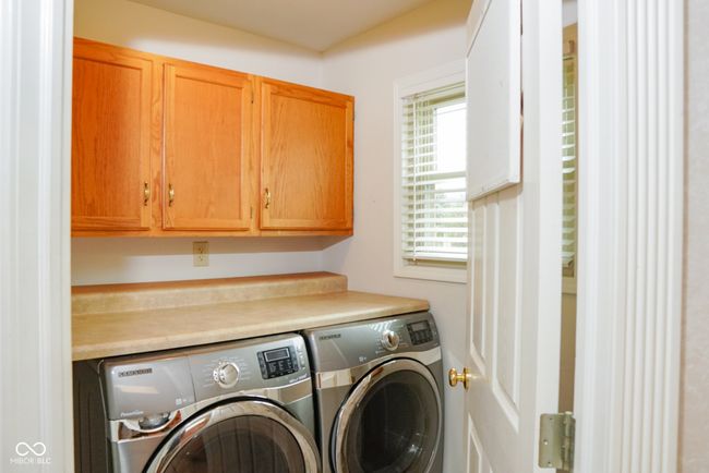 clothes washing area featuring washing machine and clothes dryer and cabinet space, and an area for a sink | Image 12