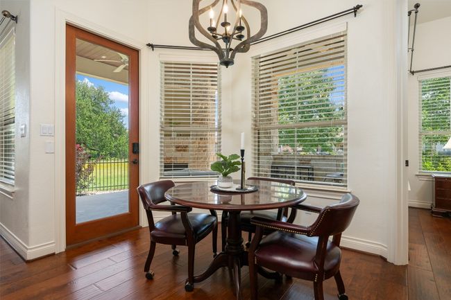 Dining space with dark wood finished floors and a chandelier | Image 10