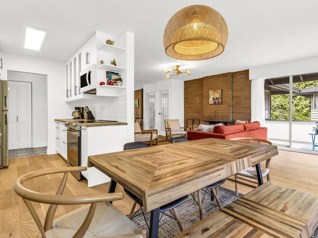Dining room with light wood-style floors, a fireplace, and baseboards | Image 6