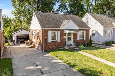 Bungalow featuring a garage, a front yard, and an outbuilding | Image 2