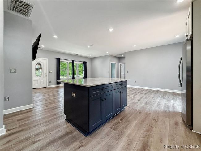 Kitchen with freestanding refrigerator, open floor plan, light wood-style floors, a kitchen island, and recessed lighting | Image 14