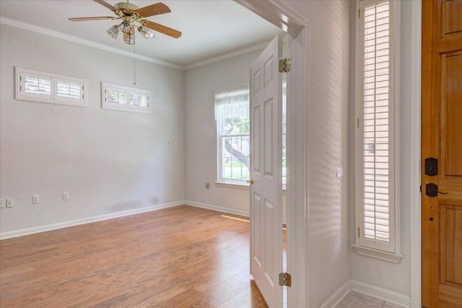 Entrance foyer featuring a ceiling fan, crown molding, and light wood finished floors | Image 5