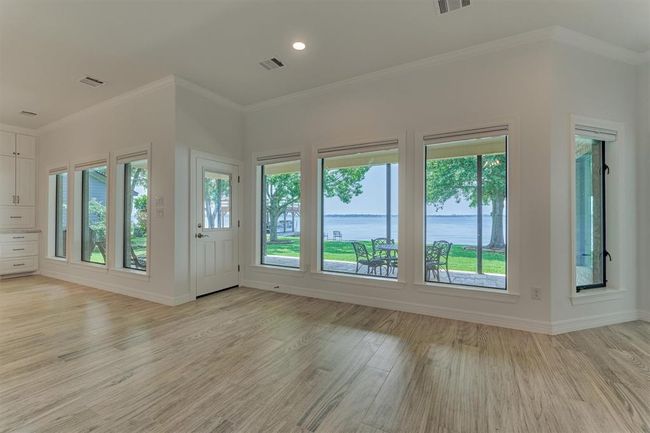 New energy efficient windows were installed along the rear of the home to maximize lake views and improve insulation. Custom shades offer the flexibility to raise or lower for both privacy and light control, allowing you to tailor the ambiance to your preference. | Image 10