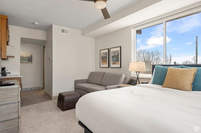Bedroom featuring light colored carpet, ceiling fan, and baseboards | Image 39