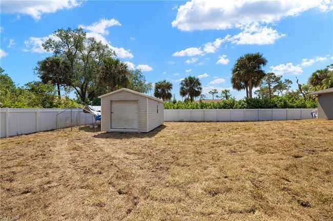 View of yard featuring a storage unit, a fenced backyard, and an outdoor structure | Image 26
