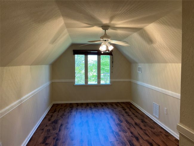 Bonus room featuring vaulted ceiling, a ceiling fan, dark wood-type flooring, and visible vents | Image 21