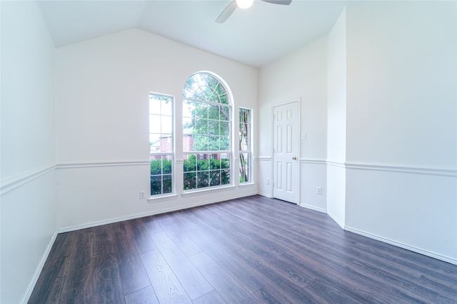 Spare room featuring dark wood-type flooring, ceiling fan, and lofted ceiling | Image 31