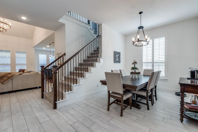 Dining space featuring recessed lighting, an inviting chandelier, light wood-type flooring, baseboards, and stairs | Image 4