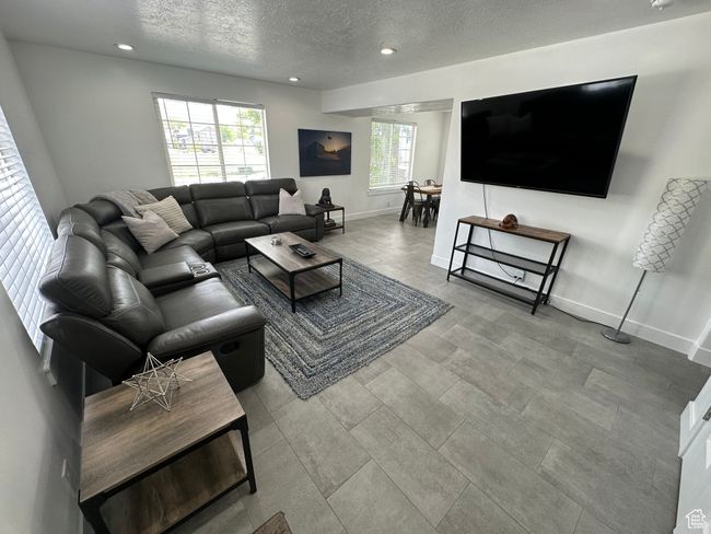 Living room with a textured ceiling, recessed lighting, and baseboards | Image 7