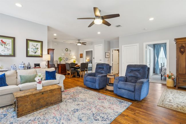 Living area featuring wood plank laminate flooring, ceiling fan, recessed lighting, and visible vents | Image 10