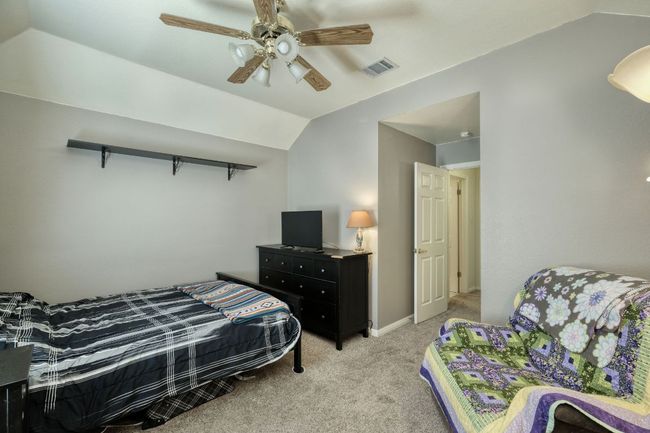 Bedroom featuring lofted ceiling, visible vents, a ceiling fan, and light carpet | Image 21