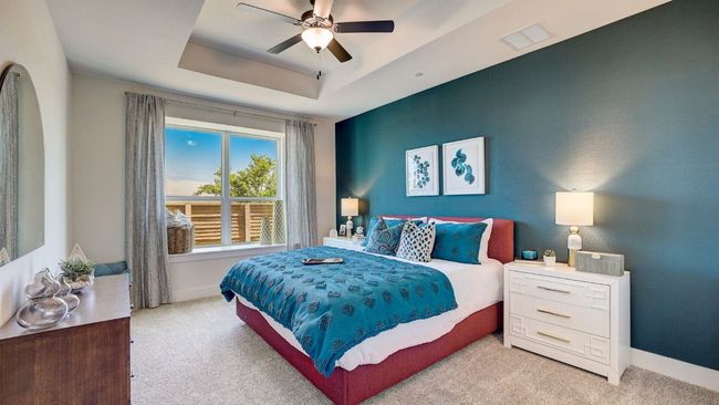 Bedroom featuring carpet floors, a raised ceiling, baseboards, and a ceiling fan | Image 5