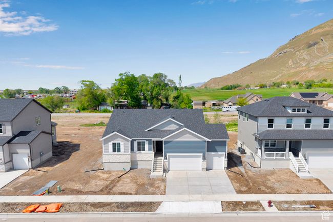 View of front facade featuring a mountain view, concrete driveway, an attached garage, and a residential view | Image 31