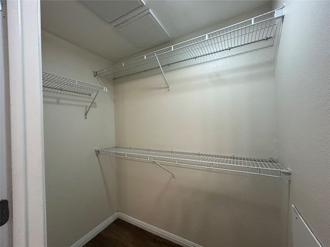 Spacious closet with dark wood-style floors | Image 15