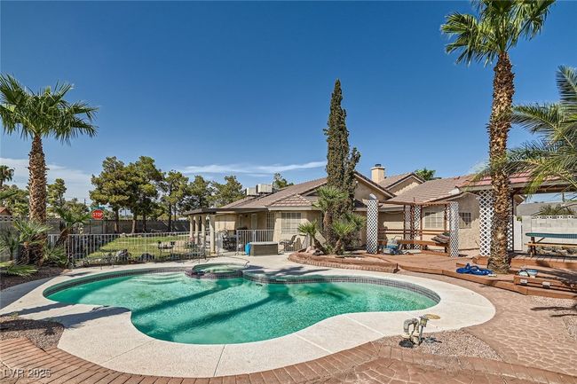 View of pool featuring a pool with connected hot tub, fence, and a patio | Image 26