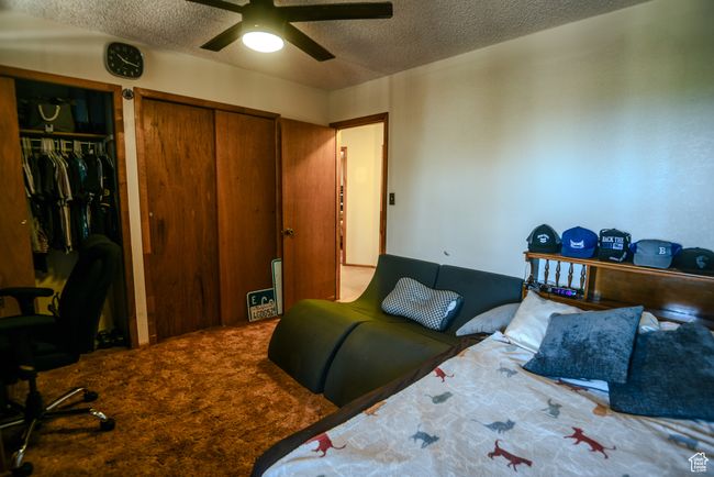 Bedroom featuring a textured ceiling, multiple closets, carpet floors, and a ceiling fan | Image 36