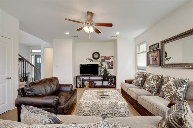Living room with stairs, wood finished floors, a ceiling fan, and recessed lighting | Image 8
