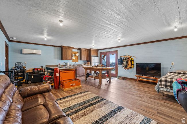 Living room with ornamental molding, an AC wall unit, and hardwood / wood-style floors | Image 54
