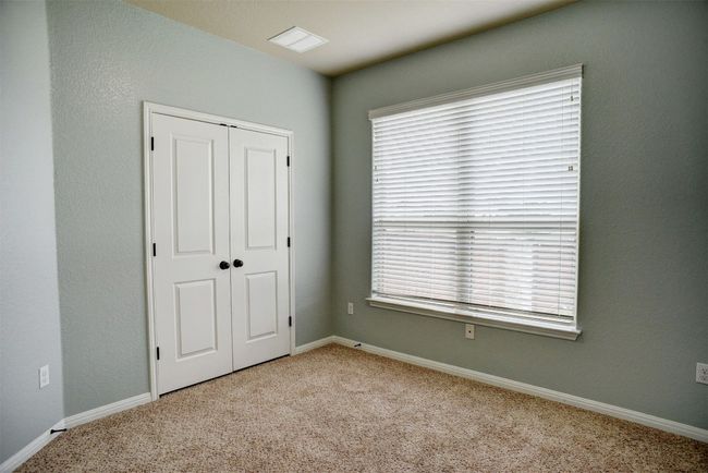 Unfurnished bedroom with carpet floors, a closet, and multiple windows | Image 25