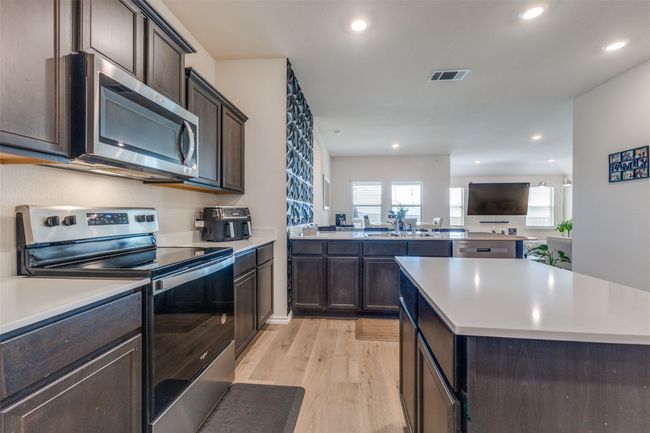 Kitchen featuring light countertops, stainless steel appliances, and visible vents | Image 5