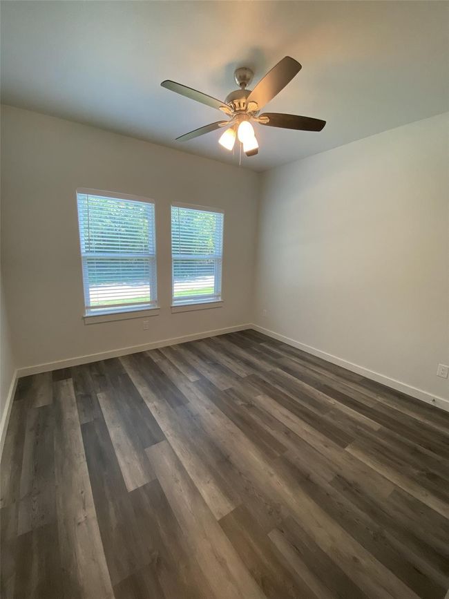 Unfurnished room featuring baseboards, ceiling fan, and dark wood finished floors | Image 8