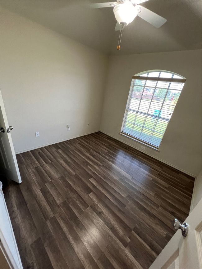 Spare room featuring dark wood-style flooring and a ceiling fan | Image 39