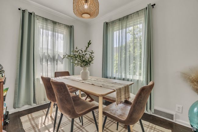Dining area with healthy amount of natural light, crown molding, wood finished floors, and baseboards | Image 11