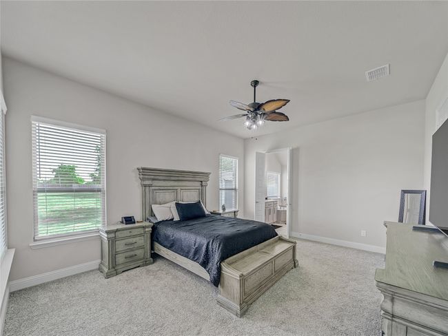 Bedroom with light carpet, a ceiling fan, and connected bathroom | Image 19