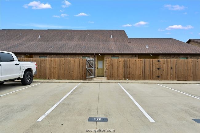 Uncovered parking lot featuring fence | Image 21