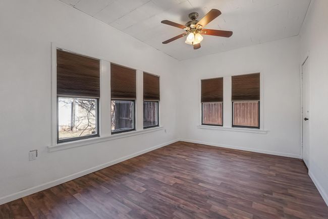 Spare room with dark wood-type flooring and ceiling fan | Image 24