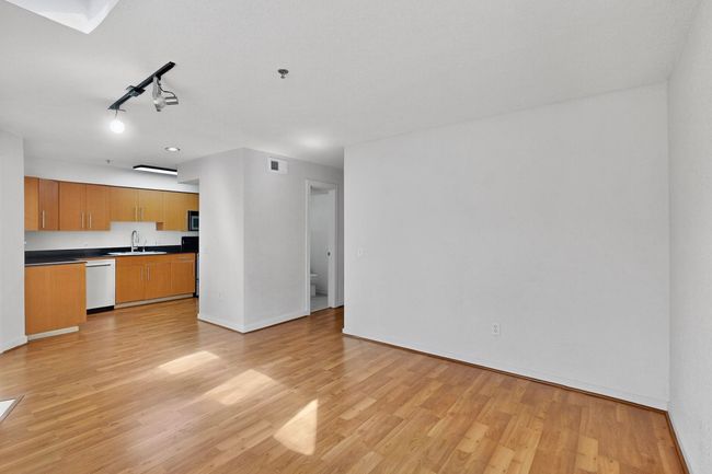 Unfurnished living room with rail lighting and light wood-style flooring | Image 16