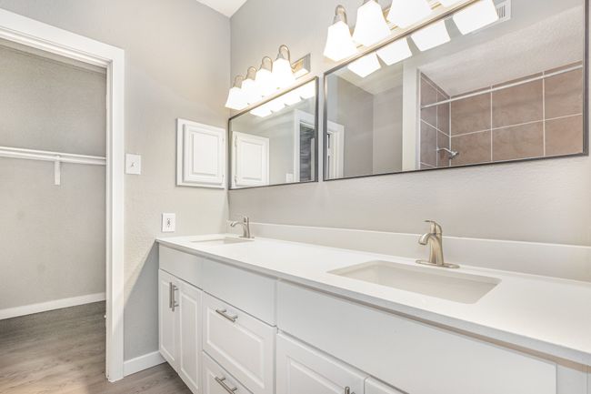 Bathroom with wood finished floors, baseboards, and double vanity | Image 17