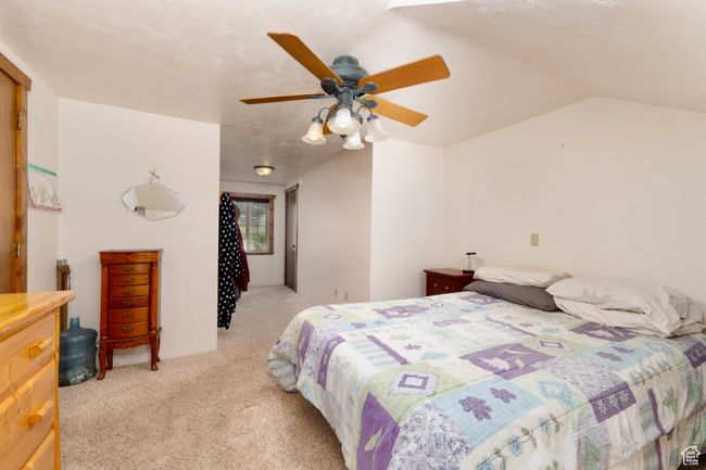 Bedroom with light carpet, a ceiling fan, and lofted ceiling | Image 22