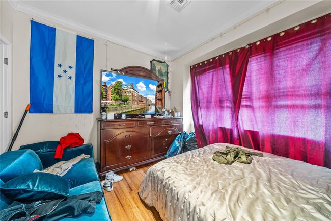 Bedroom featuring crown molding, visible vents, and wood finished floors | Image 29