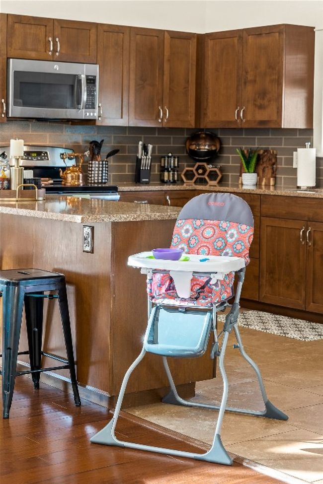 Kitchen with stainless steel appliances, decorative backsplash, dark wood finished floors, and light stone counters | Image 28