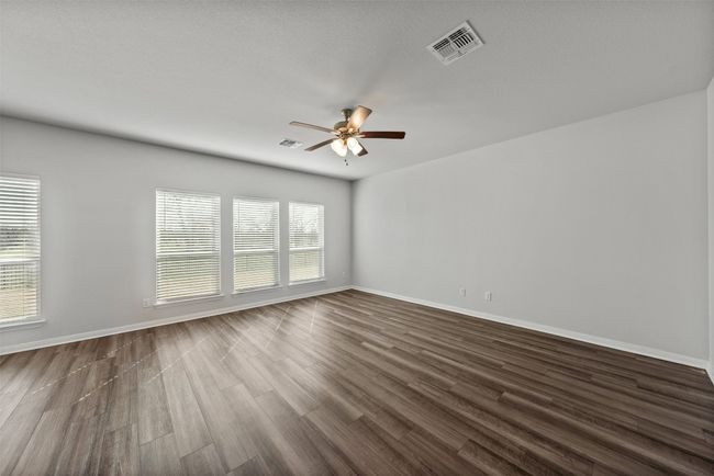 Spare room featuring ceiling fan, plenty of natural light, and wood-look tile floors | Image 6