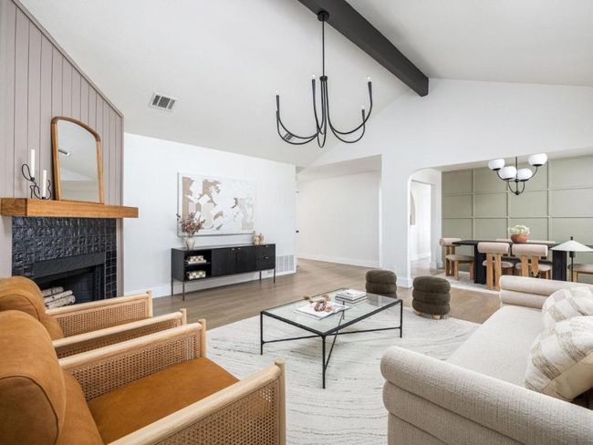 Living room with visible vents, wood finished floors, arched walkways, vaulted ceiling with beams, and an inviting chandelier | Image 11