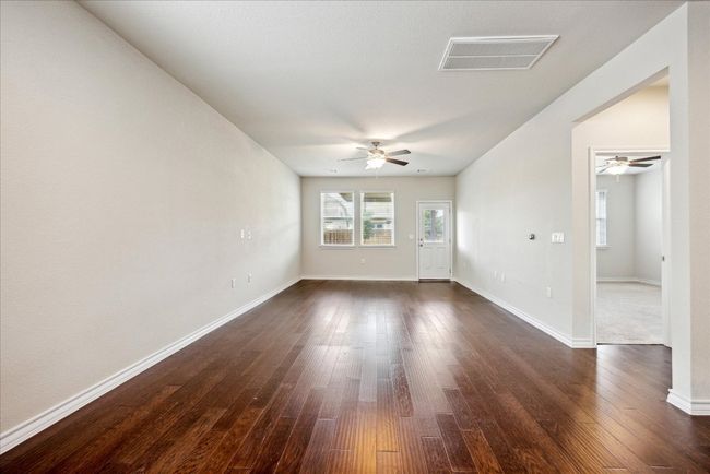 Empty room with visible vents, dark wood finished floors, and ceiling fan | Image 5