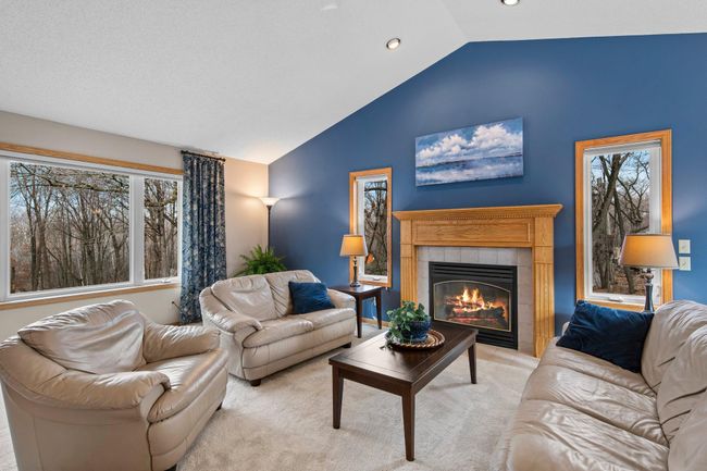 Fireplace with wood mantle features windows on either side for additional natural light | Image 6