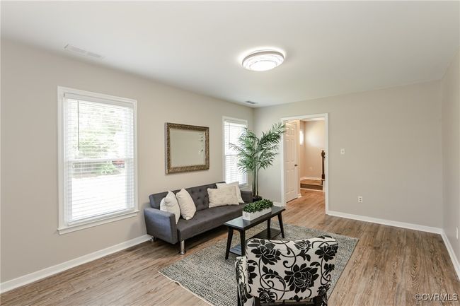 Living room with light wood-type flooring, visible vents, and baseboards | Image 13
