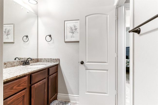 The Hollywood-style bathroom connects two upstairs guest bedrooms, offering shared access from both rooms. This layout provides added convenience and privacy for guests, with separate areas for the vanity and shower. It’s a practical feature that enhances the flow between the bedrooms. | Image 36