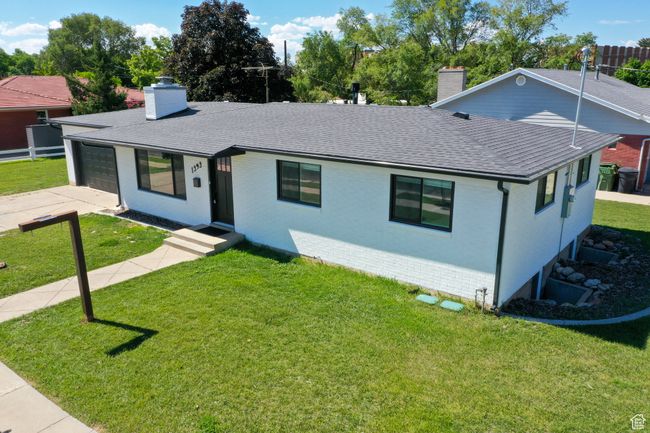 View of front of house featuring a chimney, a shingled roof, an attached garage, and a front lawn | Image 4