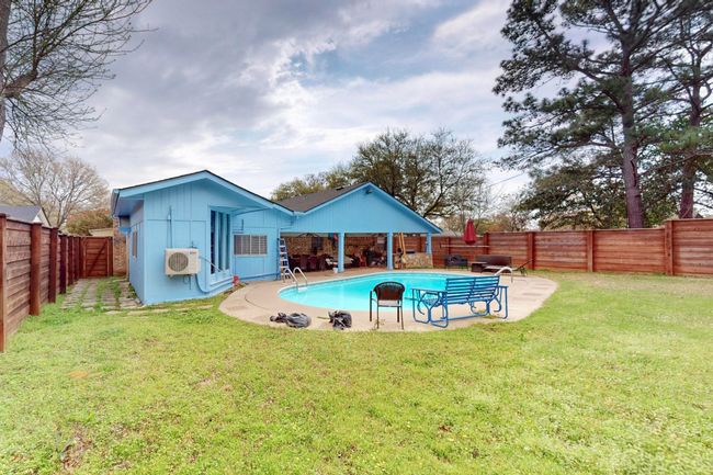 View of swimming pool with a lawn, a wall mounted AC, a fenced backyard, and a patio area | Image 37
